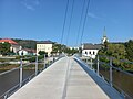 Schulgebäude und die Kirche St. Peter und Paul von der Fußgängerbrücke über Berounka