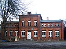 Bahnhof, bestehend aus Empfangsgebäude, Güterschuppen, Toilettenhaus, Wasserturm und Streckenwärterhaus