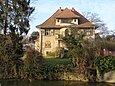 Alte Villa zwischen Bäumen am Fluss