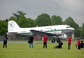 Un Douglas DC-3 (G-ANAF) de l'Air Atlantique Historic Flight décollant d'Hullavington Airfield, Wiltshire, Angleterre. L'appareil était utilisé par Air Atlantique pour le compte de Thales, pour le développement du radar du Nimrod. Le radôme visible sous le cockpit contient l'antenne parabolique rotative de ce dernier.