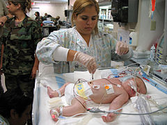 A Resperatory Therapist treating a newborn child Pulaski County Technical College Respiratory Therapist Program.jpg