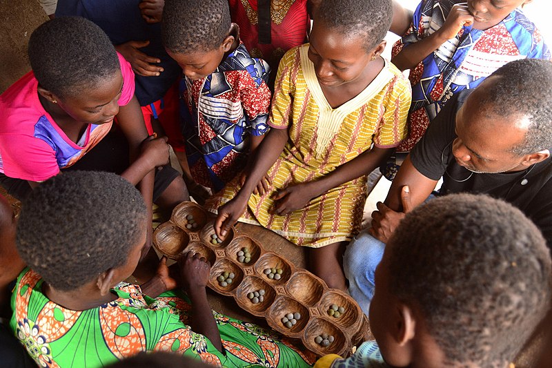 File:Children gather around a game of Ayo.jpg