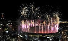 Photographie nocturne d'un feu d'artifice au-dessus d'un stade.