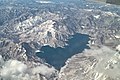 Photo couleur d'un lac entouré de montagnes vu du ciel.