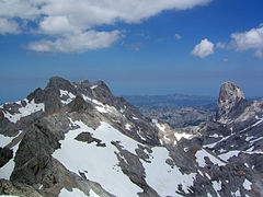 Vista desde la cumbre hacia el norte: Torre Cerredo, a la izquierda; el Naranjo de Bulnes, a la derecha; y la sierra de Cuera al fondo.