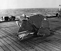 Remains of en:Yokosuka D4Y "Suisei" aircraft tail section (starboard elevator unit) aboard USS Kitkun Bay (CVE 71) after Kamikaze attack. The Judy made a run on the ship approaching from dead astern, it was met by effective fire and the plane passed over the island and exploded. Parts of the plane and the pilot were scattered over the flight deck and the forecastle.