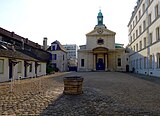 La chapelle, la petite place attenante et l'accès au cimetière au fond, à gauche.