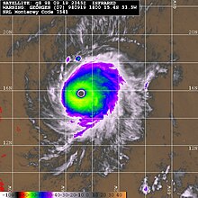 Multicolored satellite image of hurricane, with a clear eye at its center.