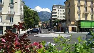 Photographie en couleurs d'une montagne en arrière-plan dans l'enfilade de la rue d'une ville.