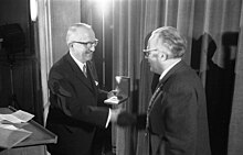 Walter Hallstein on stage, shaking hands while receiving prize.