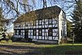 Pfarrhaus mit Nebengebäuden, Taufstein im Garten