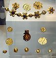 Offerings found in Bodh Gaya under the "Enlightenment Throne of the Buddha", with a decorated coin of the Kushan emperor Huvishka, 3rd century CE (British Museum)[೨]