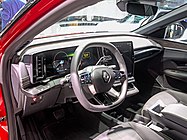 Dashboard of a left-hand-drive car with digital dials, a satellite-navigation screen, and a column-mounted automatic gear selector