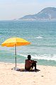 Homme sous un parasol de plage.