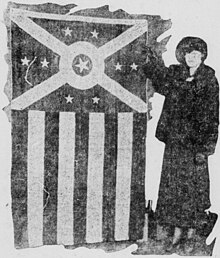 A woman gesturing to the flag