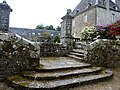 Château de Trégarantec : l'escalier d'honneur, fermé par deux piliers entourés d'une balustrade en granite ouvragé, vu côté jardin.