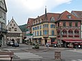 View to a street: Place du Marché-rue Saint-Gregoire-Grand Rue with townhall