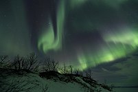 Солнечный ветер, движущийся через магнитосферу, изменяет движение заряженных частиц в термосфере или экзосфере Земли, и возникающая в результате ионизация этих частиц заставляет их излучать свет разного цвета, образуя таким образом полярные сияния вблизи полярных регионов.