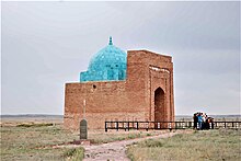 A brick mausoleum with a blue roof