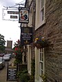 The pub's main entrance in 2011, including a sign for W. M. Youngers Brewery. St Oswald's Church is in the background