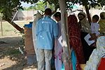 Australian medic conducts triage in the shade of a tree. Pakistan 2010.