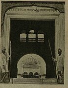 Photograph captioned 'The Last Sikhs of Nankana Sahib, October 1947', showing two Sikhs guarding the entrance gateway (Darshani Deori) of Gurdwara Janam Asthan, Nankana Sahib.jpg