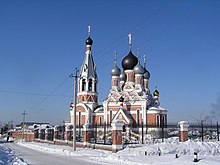 Large Orthodox church in the snow, against a blue sky