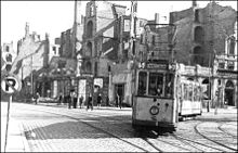 Tramwaj typu Bremen na placu Żołnierza Polskiego. Za nim mocno zniszczone kamienice.