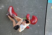 A climber using the toe-hooking technique on an indoor climbing wall