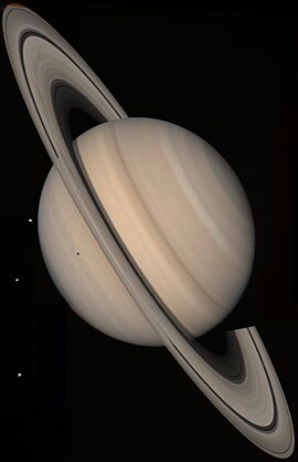 Foto de Saturno utignìda de la Voyager 2 ai 4 de óst del 1981 a presapóch 21 miliù de km. Se èt tré dei sò satèliti gisàcc sö la sinìstra; en ùrden de distànsa del pianeta: Teti, Dione e Rea. L'ombra de Teti l'è proietàda sö l'emisfér sud de Saturno.