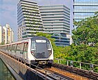 Un train gris parcouru d'une ligne rouge arrêté à une gare.