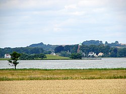 Skanderborg Sø set fra øst mod Kalvø og med Skanderborg Slotskirke i baggrunden. Bøgetræerne bag det røde kirketårn, er Skanderborg Dyrehave.