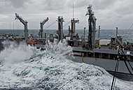 Un bâtiment militaire embarquant une lame sur son pont inférieur.