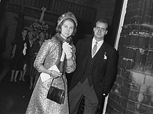 Photographie d'un couple, dont la femme porte un manteau brodé, une toque et une écharpe en fourrure et l'homme un costume trois pièces.