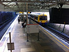 Een treinstel van de overground rijdt binnen op Watford High Street