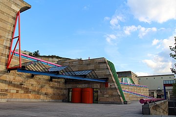 Contradiction (in this case, the mix between monumental curving forms, columns, bossages, but also other Classical elements, and High-Tech glazing, with highly saturated colours) – Neue Staatsgalerie, Stuttgart, Germany, by James Stirling (1984)[45]