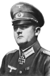 A man wearing a peaked cap and military uniform with an Iron Cross displayed at the front of his uniform collar.