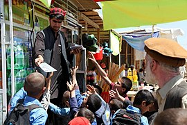 Afghan children request leaflets in a Bagram bazaar.jpg