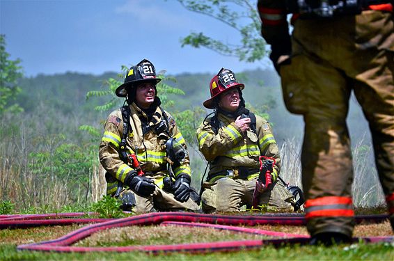 Two Calera, Alabama firefighters pause during a battle against a residential housefire on April 27, 2016