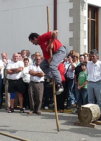 Homme grimpant sur un pieu le 28 juillet, fête nationale de la Cantabrie à Puente San Miguel (Reocín)