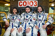 Soyuz MS-12 crew members in front of their spacecraft.jpg