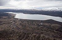 Aerial photo of a long Lake Clark with snowy mountains behind it