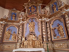 Photographie en couleurs, représentant un retable dans une église.