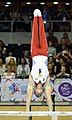 Lukas Dauser im Handstand auf einem Holm am Barren beim Mehrkampf