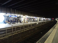 Au fond, les quais du tramway, après rénovation. Au premier plan, une voie et un quai de la gare SNCF.