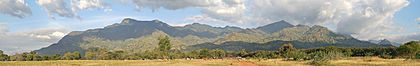 Vista panorâmica das montanhas Uluguru. As montanhas Uluguru são uma cordilheira no leste da Tanzânia, batizada em homenagem à tribo Luguru. A parte principal das montanhas é uma cordilheira que se estende aproximadamente de norte a sul e se eleva a 2 630 metros de altitude em seu ponto mais alto. Na cadeia principal, 50 vilarejos tocam o limite da floresta e mais de 151 mil pessoas são encontradas na área da montanha, geralmente em densidades crescentes em altitudes mais elevadas até o limite da floresta. (definição 6 498 × 1 016)