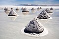 Salo-montetoj en la lago Salar de Uyuni en Bolivio