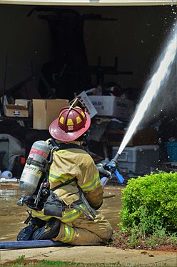 A Calera, Alabama firefighter battles a residential house fire on April 27, 2016