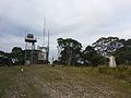 Trig point and structures at the summit of Mt. Bindo.