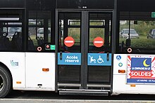 Photographie en couleurs des portes coulissantes fermées d'un minibus bleu et noir.